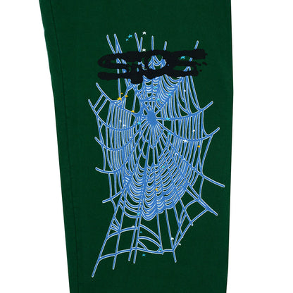 Green sweatpants with a spider web design on a white background